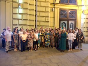 Grupa kilkudziesięciu osób stoi przed wejściem do Teatru w Lublinie.